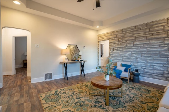 living area featuring ceiling fan and dark hardwood / wood-style flooring