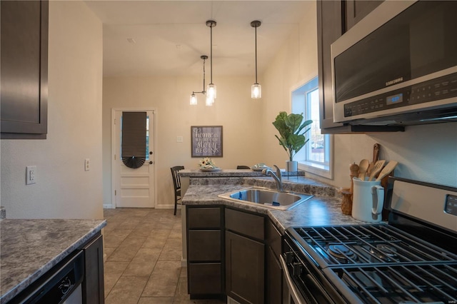 kitchen featuring sink, decorative light fixtures, dark brown cabinets, light tile patterned floors, and stainless steel appliances