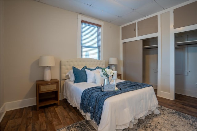 bedroom with dark wood-type flooring and multiple closets