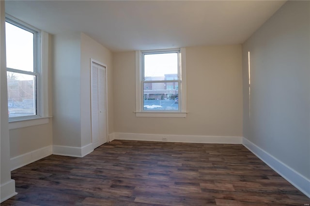 spare room featuring dark hardwood / wood-style flooring and a wealth of natural light