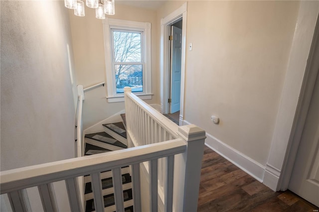 staircase with an inviting chandelier and wood-type flooring