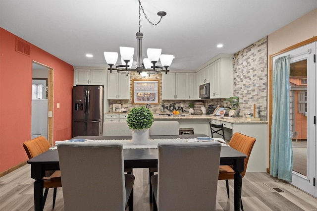 dining area featuring a chandelier and light hardwood / wood-style floors