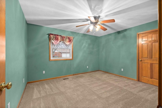 carpeted spare room with ceiling fan