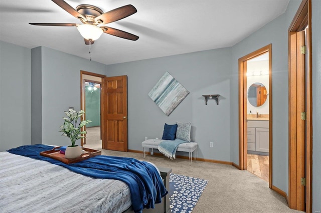 bedroom with sink, light colored carpet, ceiling fan, and ensuite bathroom