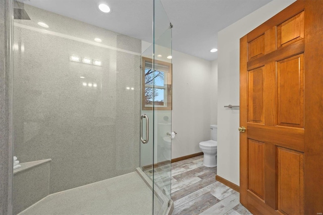 bathroom featuring wood-type flooring, toilet, and a shower with shower door