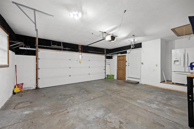 garage with a garage door opener and white fridge with ice dispenser