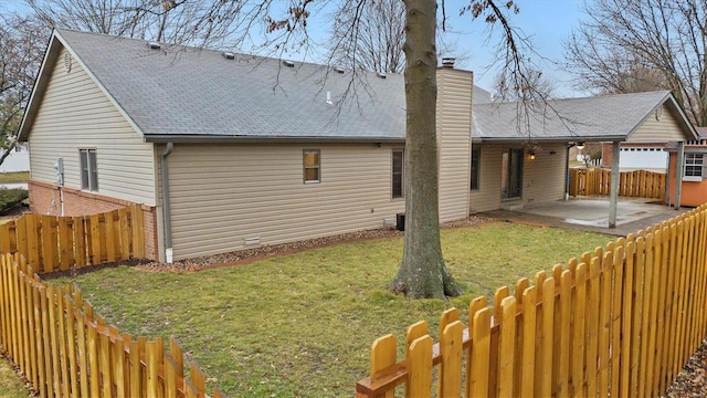 back of house with a lawn and a patio