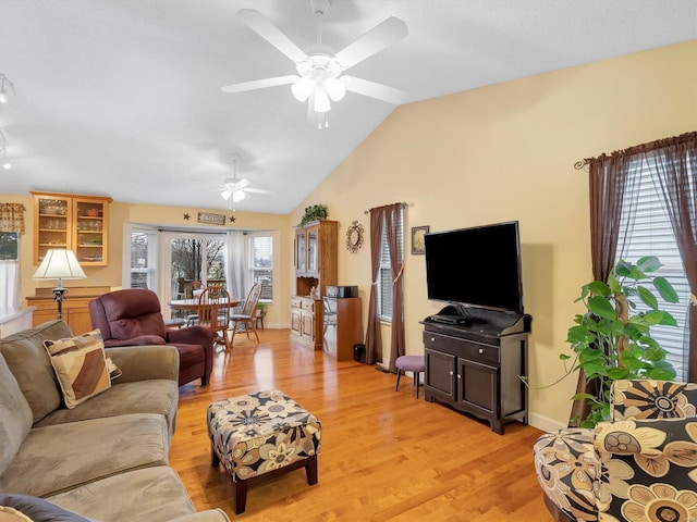 living room featuring ceiling fan, lofted ceiling, and light hardwood / wood-style flooring