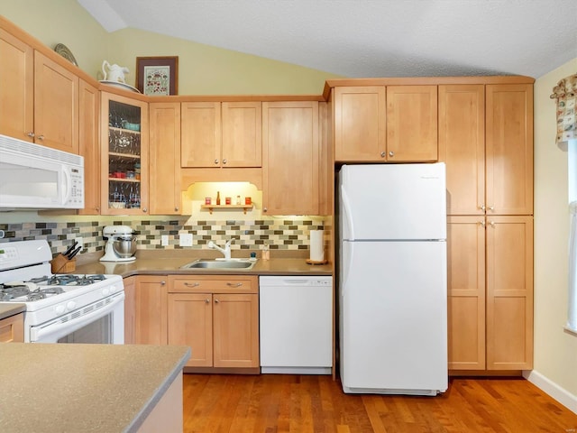 kitchen featuring vaulted ceiling, sink, decorative backsplash, white appliances, and light hardwood / wood-style flooring