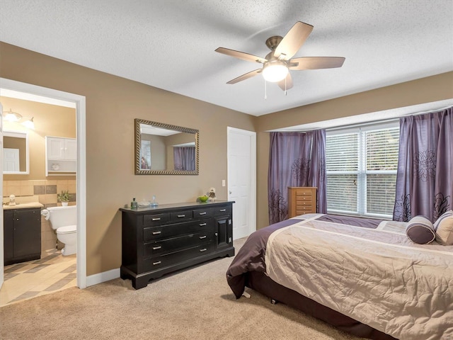 carpeted bedroom featuring ceiling fan, sink, connected bathroom, and a textured ceiling