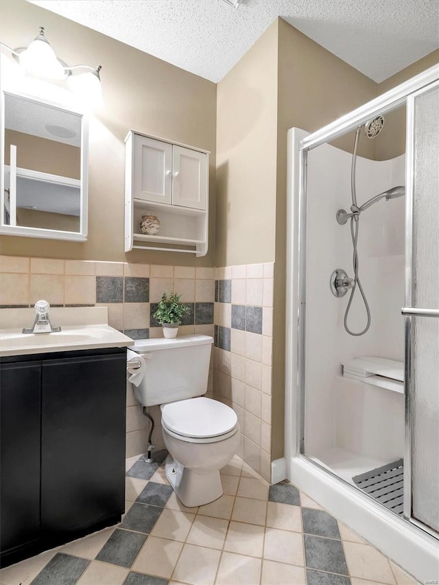 bathroom with a shower with shower door, a textured ceiling, and tile walls