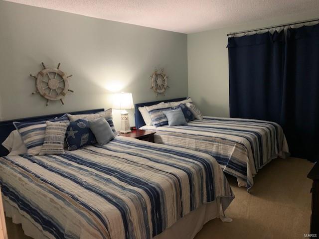 carpeted bedroom with a textured ceiling