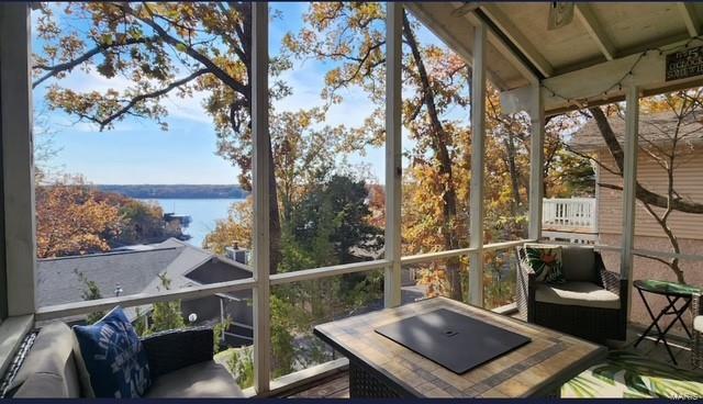 sunroom / solarium featuring a water view