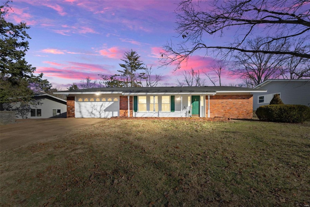 ranch-style house with a garage and a yard