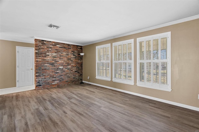 unfurnished room featuring crown molding, wood-type flooring, and brick wall