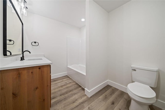 full bathroom featuring hardwood / wood-style flooring, vanity, toilet, and tub / shower combination