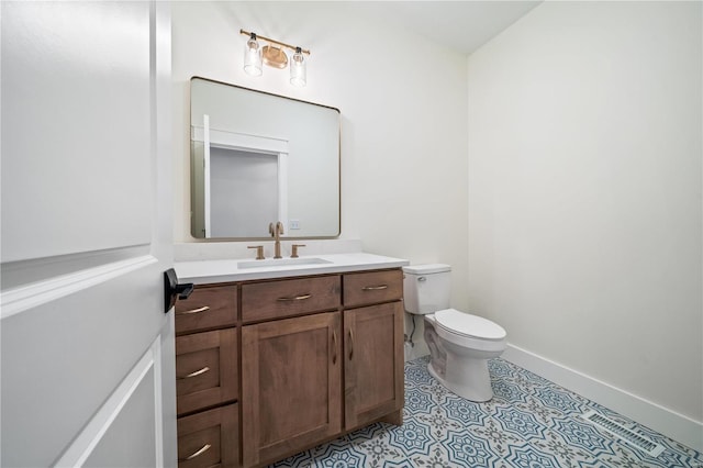 half bath with baseboards, vanity, toilet, and tile patterned floors