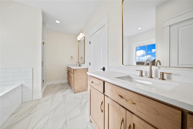 full bath with a garden tub, recessed lighting, two vanities, a sink, and marble finish floor