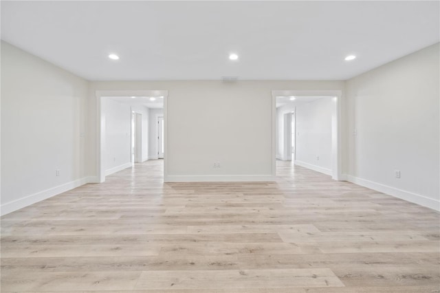 empty room featuring recessed lighting, light wood-style flooring, and baseboards