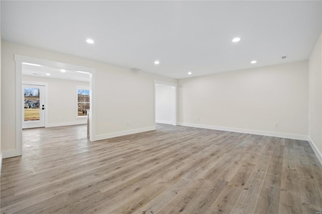 empty room featuring light wood finished floors, recessed lighting, and baseboards