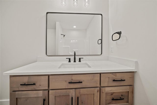 bathroom featuring walk in shower and vanity