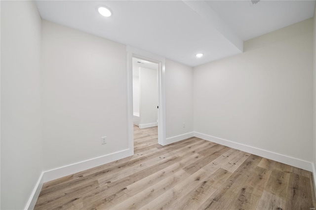 empty room featuring light wood-type flooring, baseboards, and recessed lighting