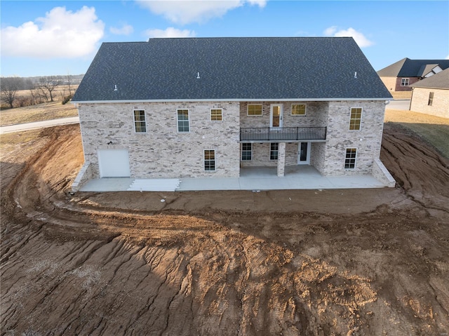 rear view of house with a patio area and roof with shingles