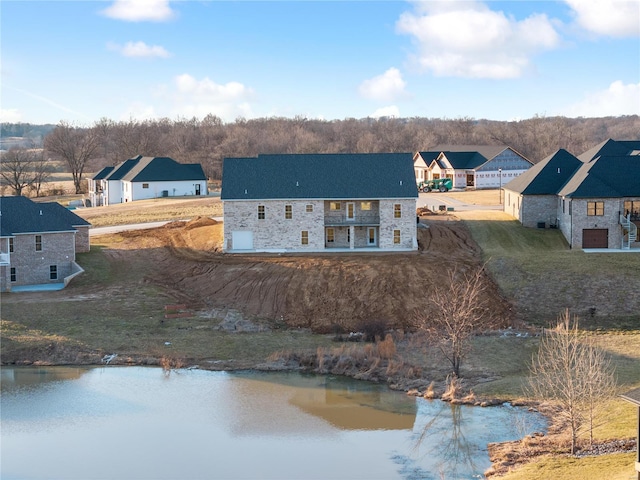 rear view of property with a residential view, stone siding, and a water view