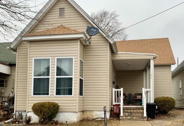 rear view of property featuring covered porch