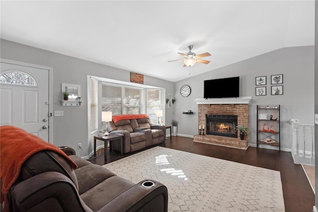 living room featuring ceiling fan, lofted ceiling, dark hardwood / wood-style flooring, and a fireplace