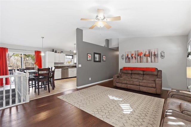 living room with ceiling fan, lofted ceiling, dark hardwood / wood-style flooring, and sink