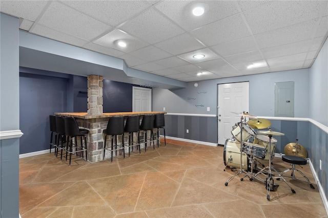 bar with a paneled ceiling and electric panel