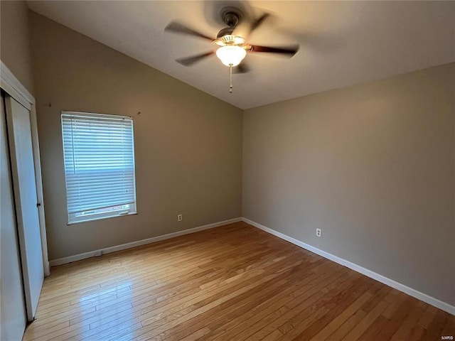 empty room with ceiling fan, lofted ceiling, and light hardwood / wood-style flooring