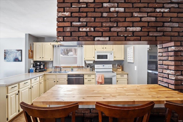 kitchen with white appliances, wooden counters, sink, and cream cabinets