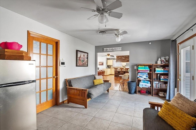 living room featuring light tile patterned flooring and ceiling fan