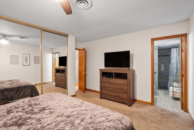 carpeted bedroom with ceiling fan, ensuite bath, and a closet