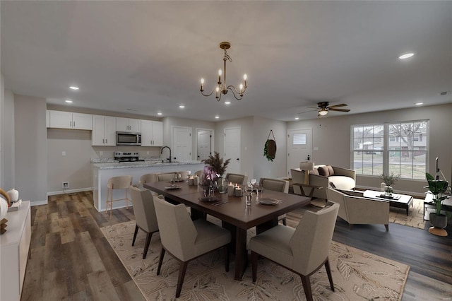 dining space featuring dark wood-type flooring, sink, and ceiling fan