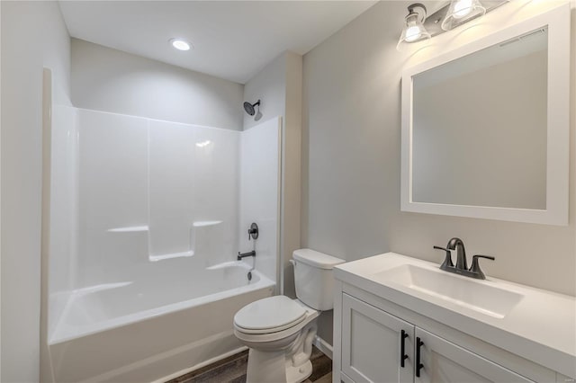 full bathroom featuring vanity, hardwood / wood-style flooring, bathtub / shower combination, and toilet