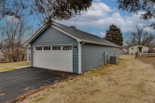 garage with central AC and a lawn