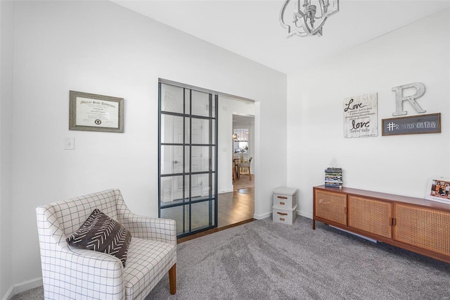 sitting room featuring a chandelier and carpet