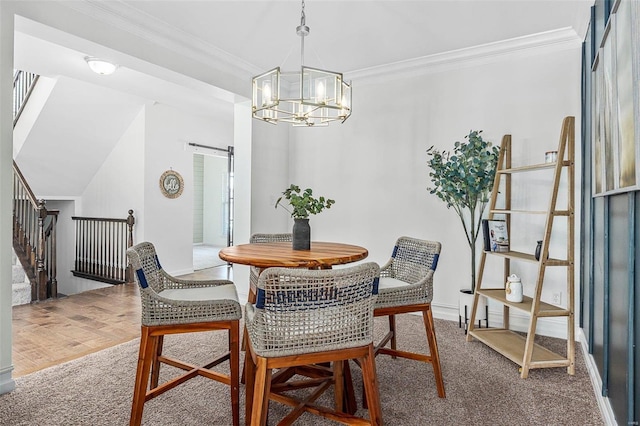 dining space featuring ornamental molding, a barn door, carpet floors, and a chandelier