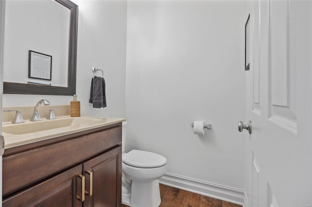 bathroom with vanity, hardwood / wood-style flooring, and toilet