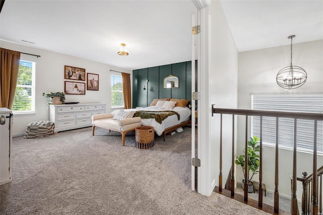 carpeted bedroom with a notable chandelier