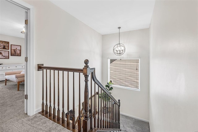 stairway featuring carpet flooring and a notable chandelier