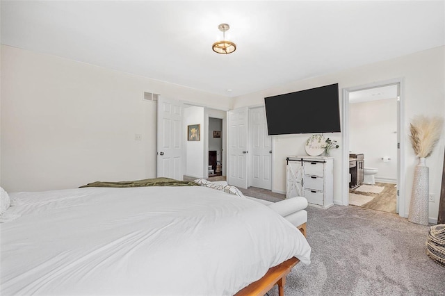 carpeted bedroom featuring ensuite bath and a closet