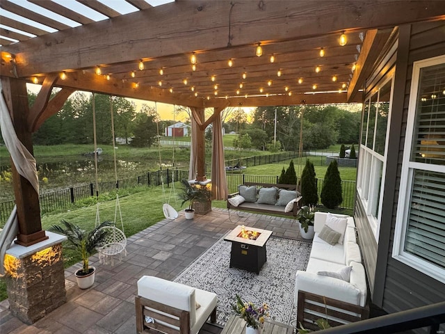 patio terrace at dusk with a pergola, a lawn, and an outdoor living space with a fire pit