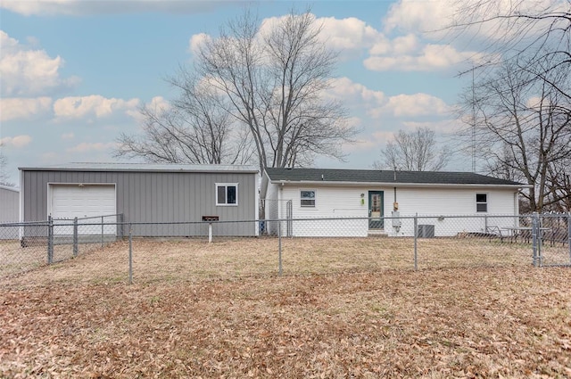 rear view of house with a garage, a yard, and an outdoor structure