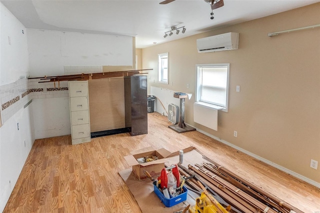 kitchen featuring ceiling fan, an AC wall unit, and light wood-type flooring