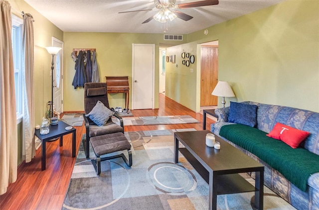 living room featuring hardwood / wood-style floors and ceiling fan