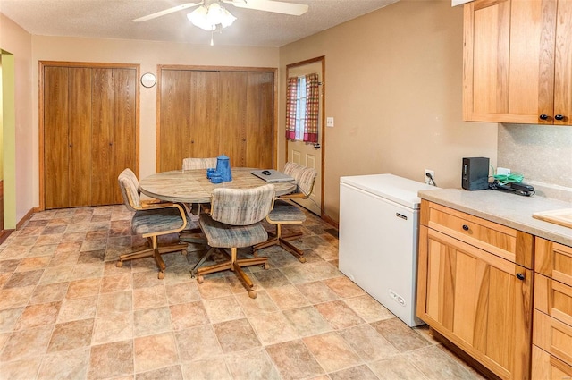 dining area with ceiling fan and a textured ceiling